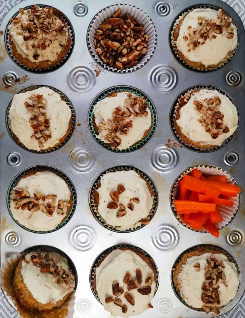 Low carb carrot cake cupcakes in a muffin tin, decorated and frosted