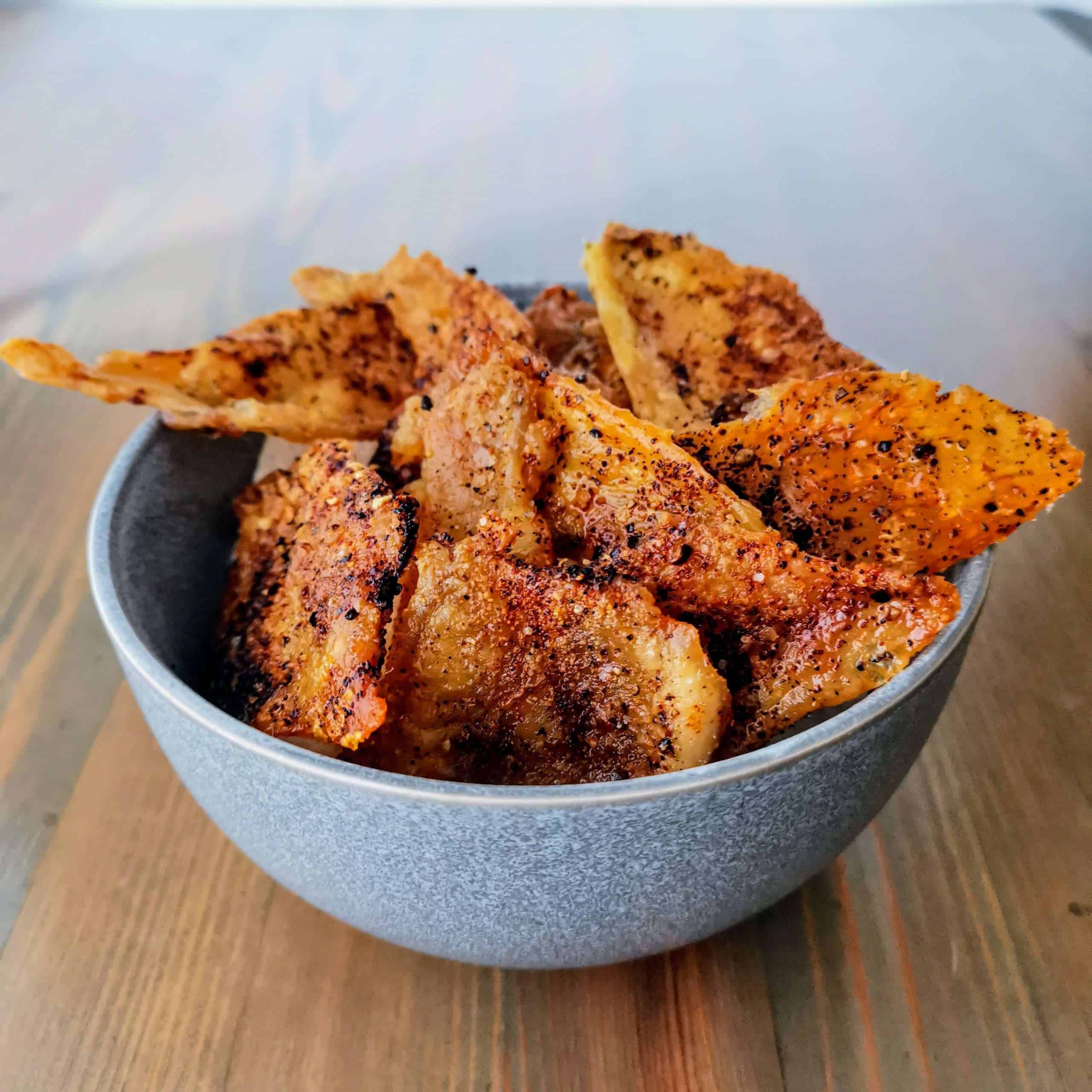 Keto friendly chicken skin nacho chips in a bowl from an angle