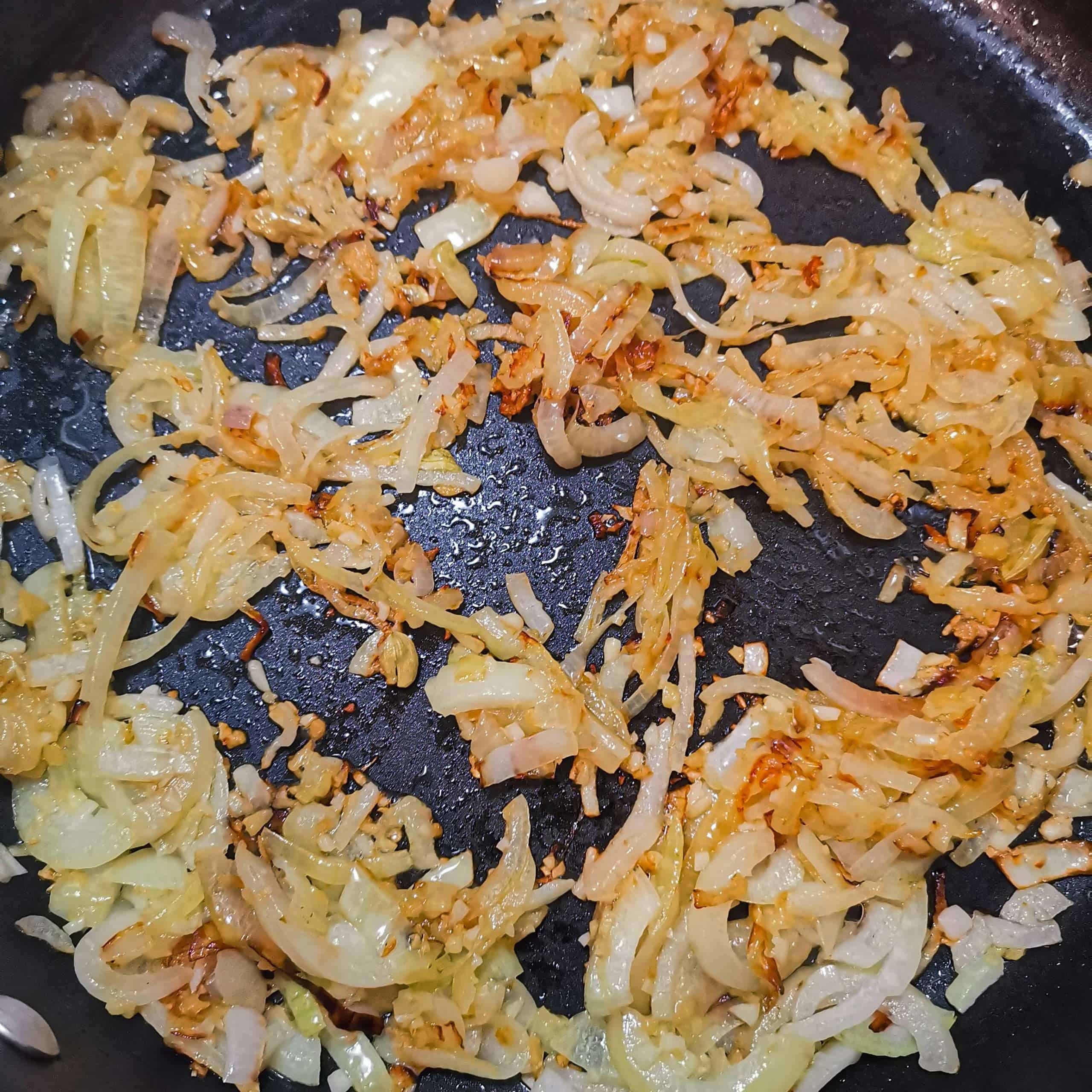 Onions ins a pan starting to brown for a curry