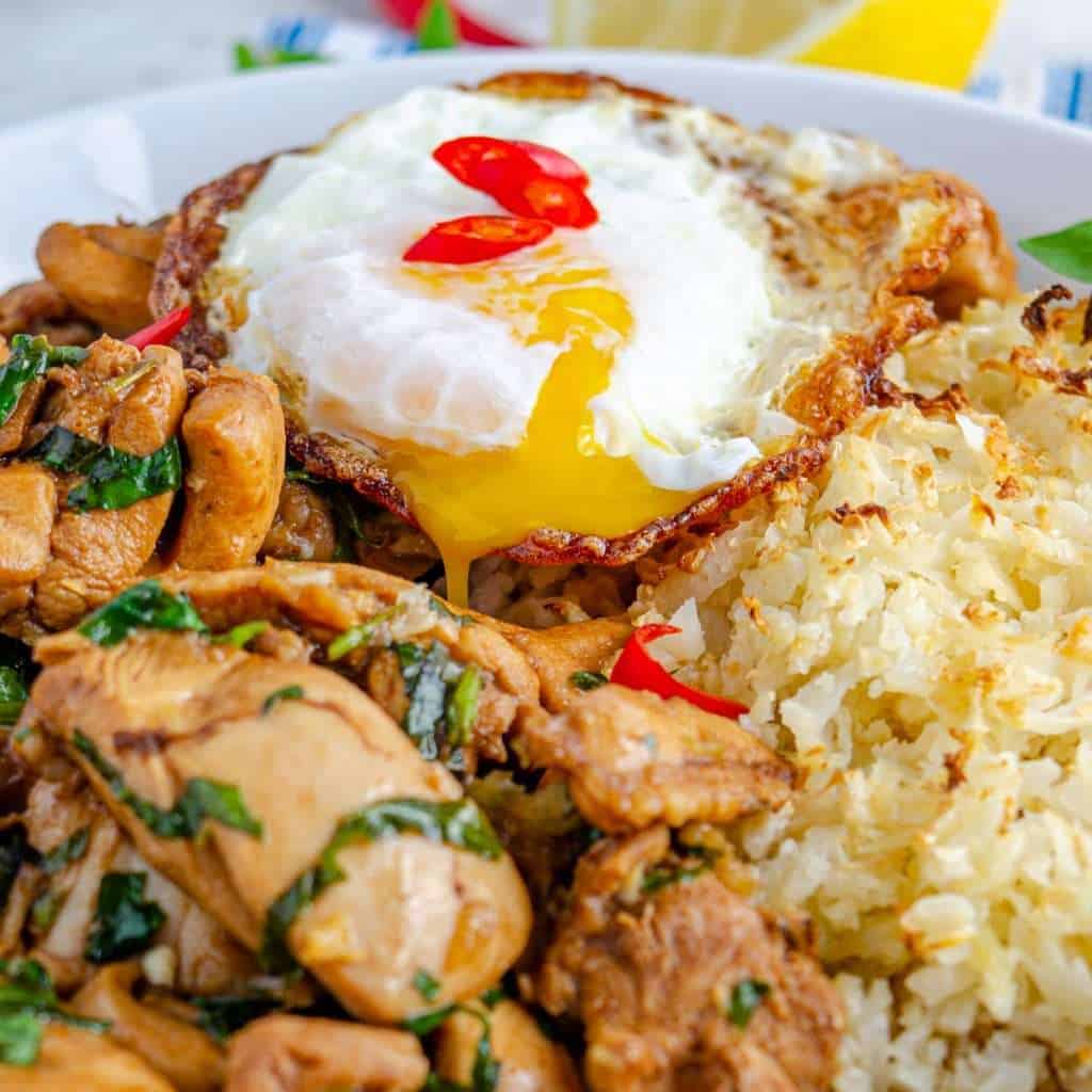 A crispy oozing fried egg over top Thai basil chicken