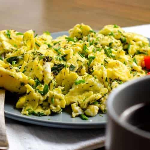 Herby Scrambed Eggs with a coffee and tomatoes