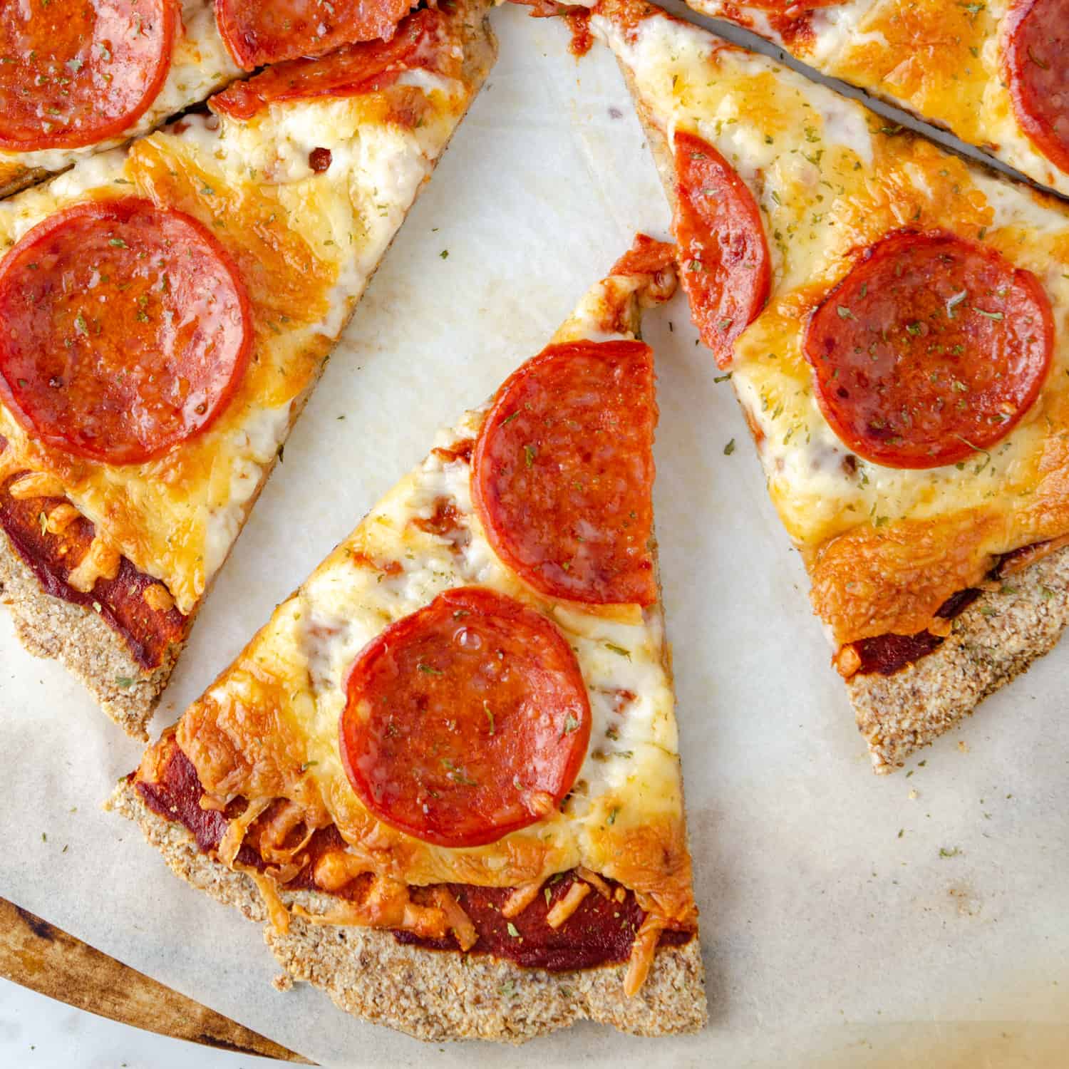 keto pepperoni pizza on a pizza stone