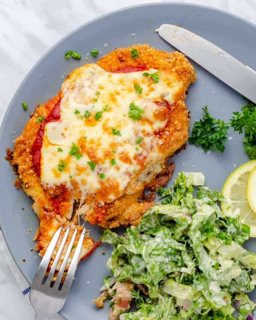 Keto Chicken Parmesan with Caesar salad on a plate