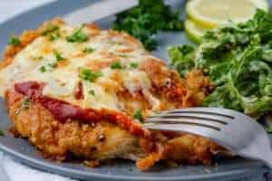 Keto Chicken Parmesan with melty cheese on a grey plate