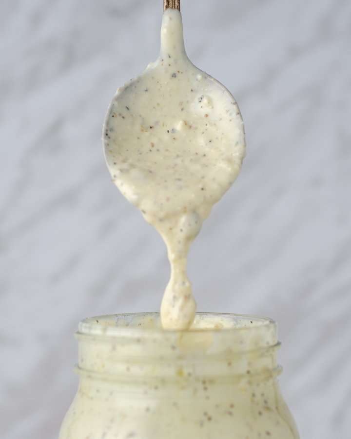 Creamy Keto Caesar Dressing dripping of a spoon