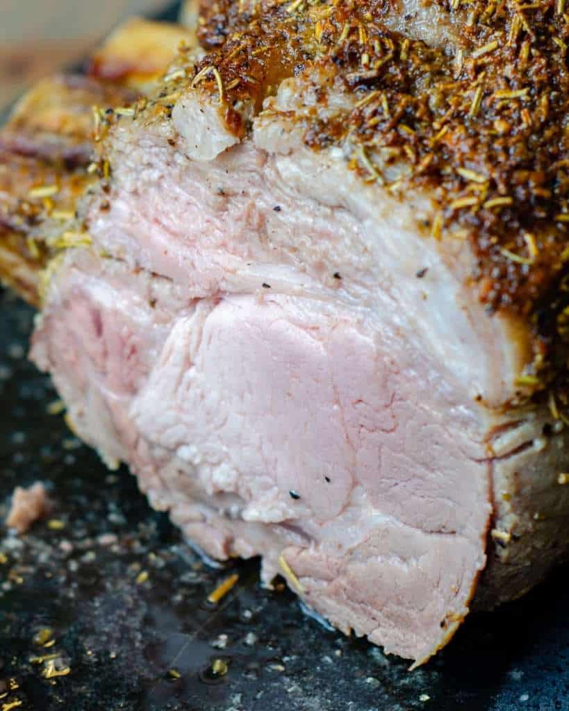 Medium cooked pork roast blushing pink with a crispy outer crust