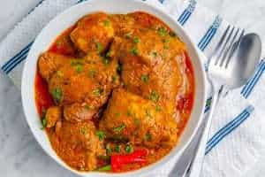 Spicy keto butter chicken looking mouthwatering in a white bowl on a marble surface