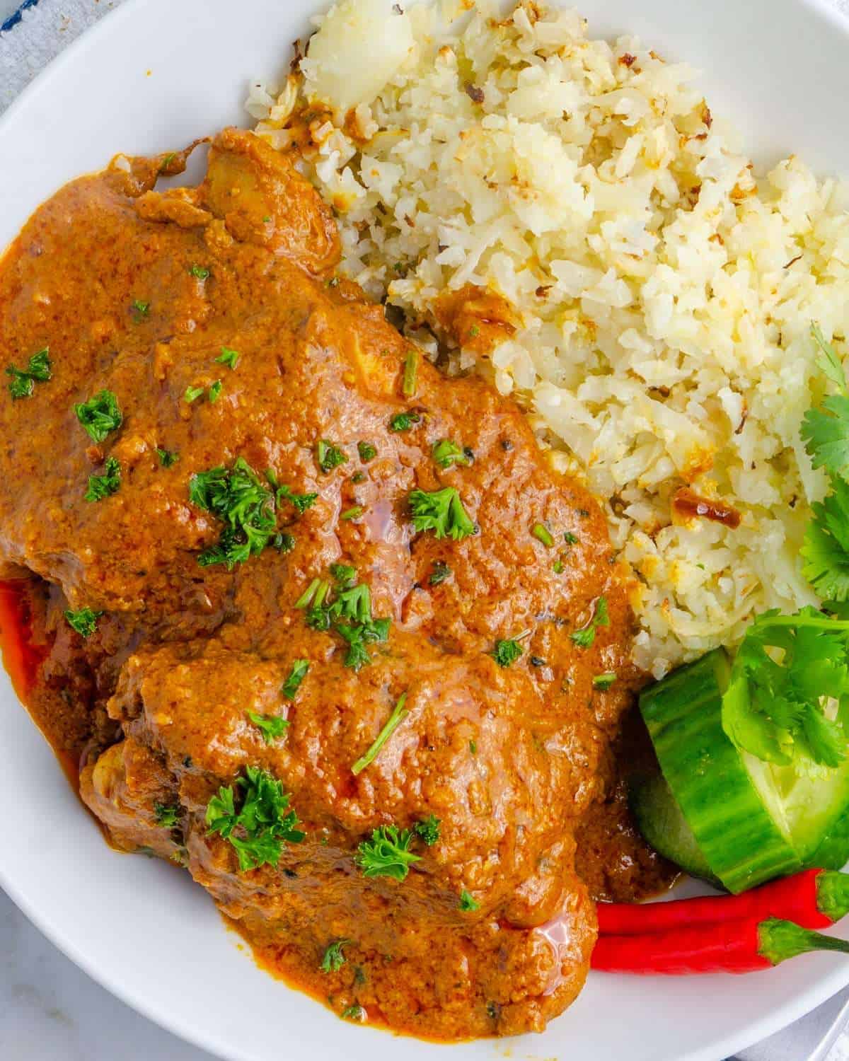 Spicy Keto Butter chicken meal with cauli rice and garnish