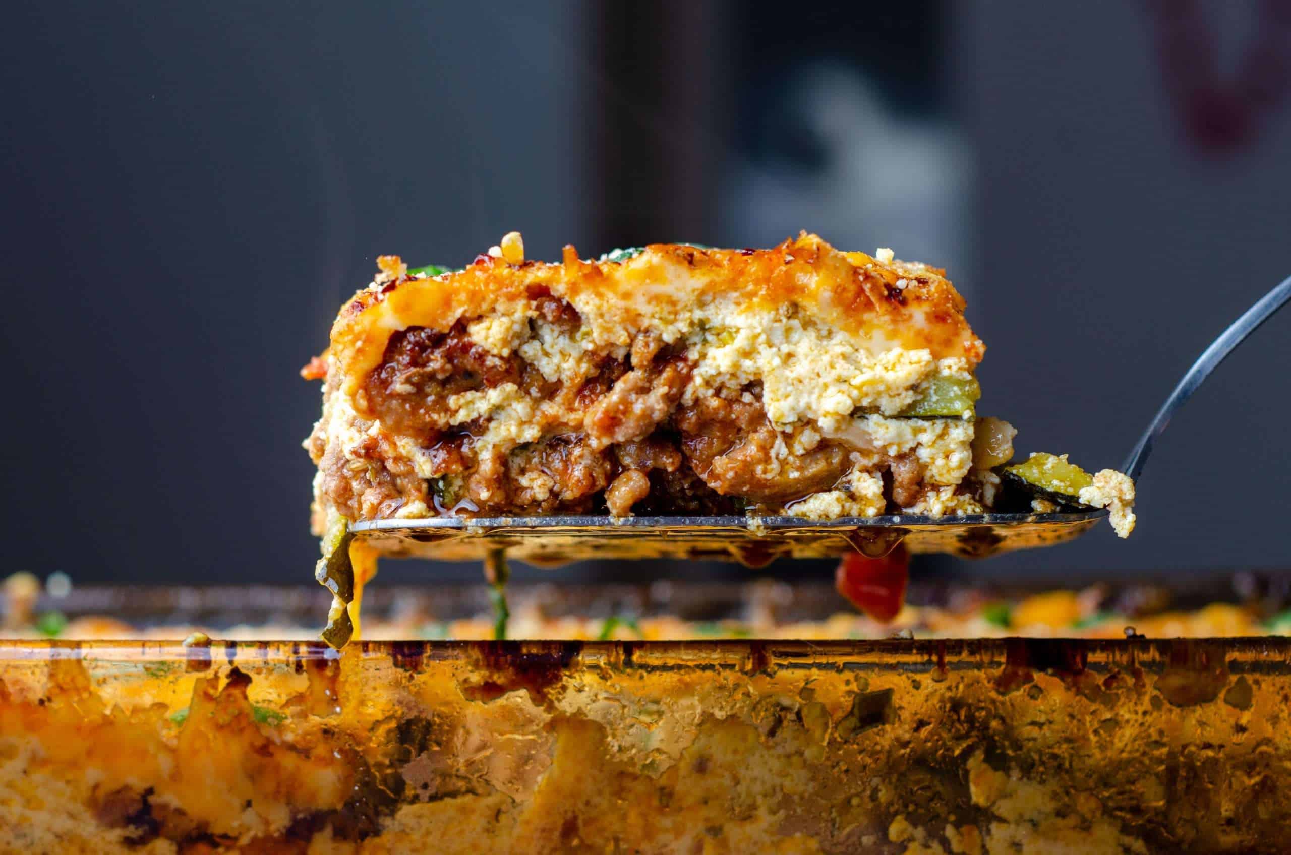 Ultimate Keto Zucchini Lasagna on a spatula over a pan