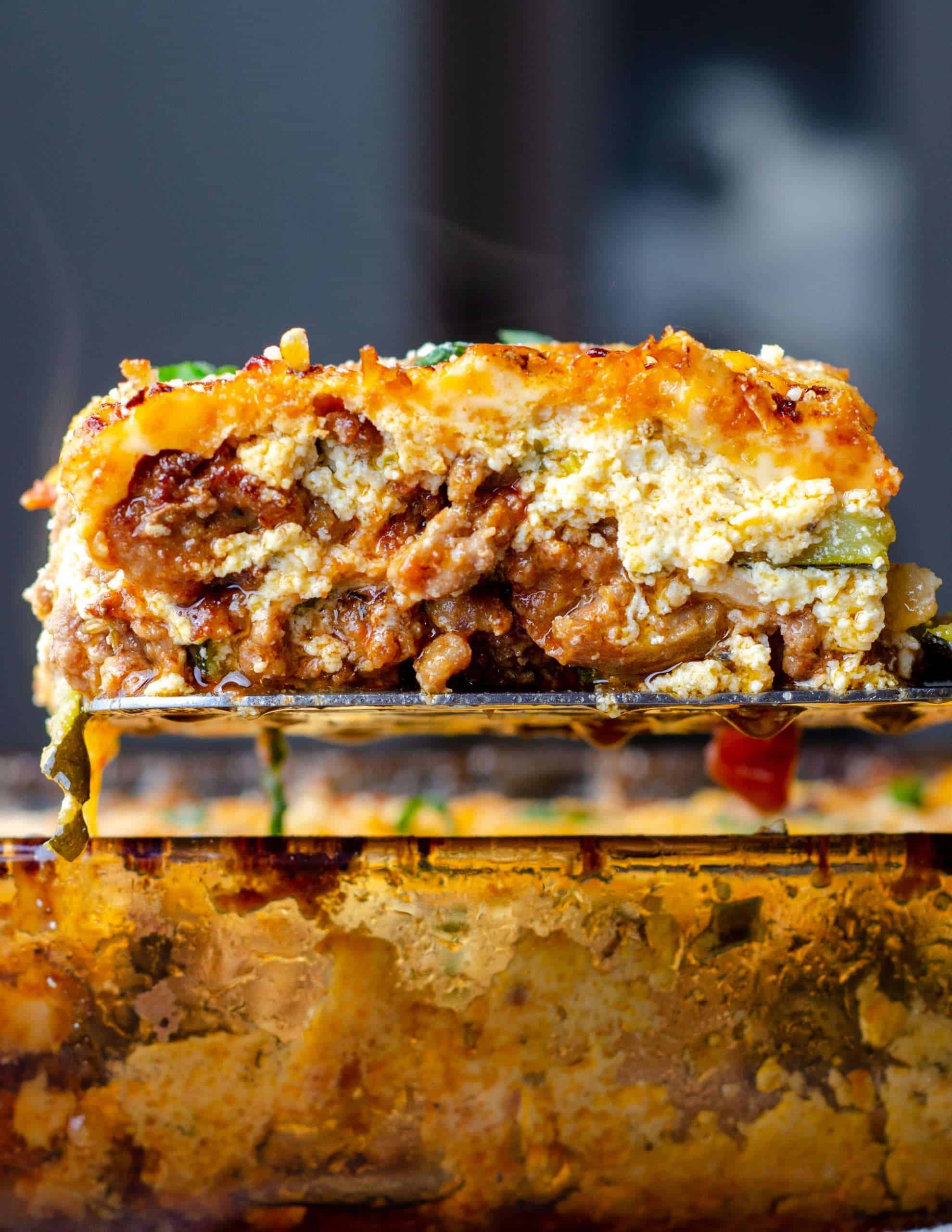 keto zucchini lasagna on a spatula over the pan