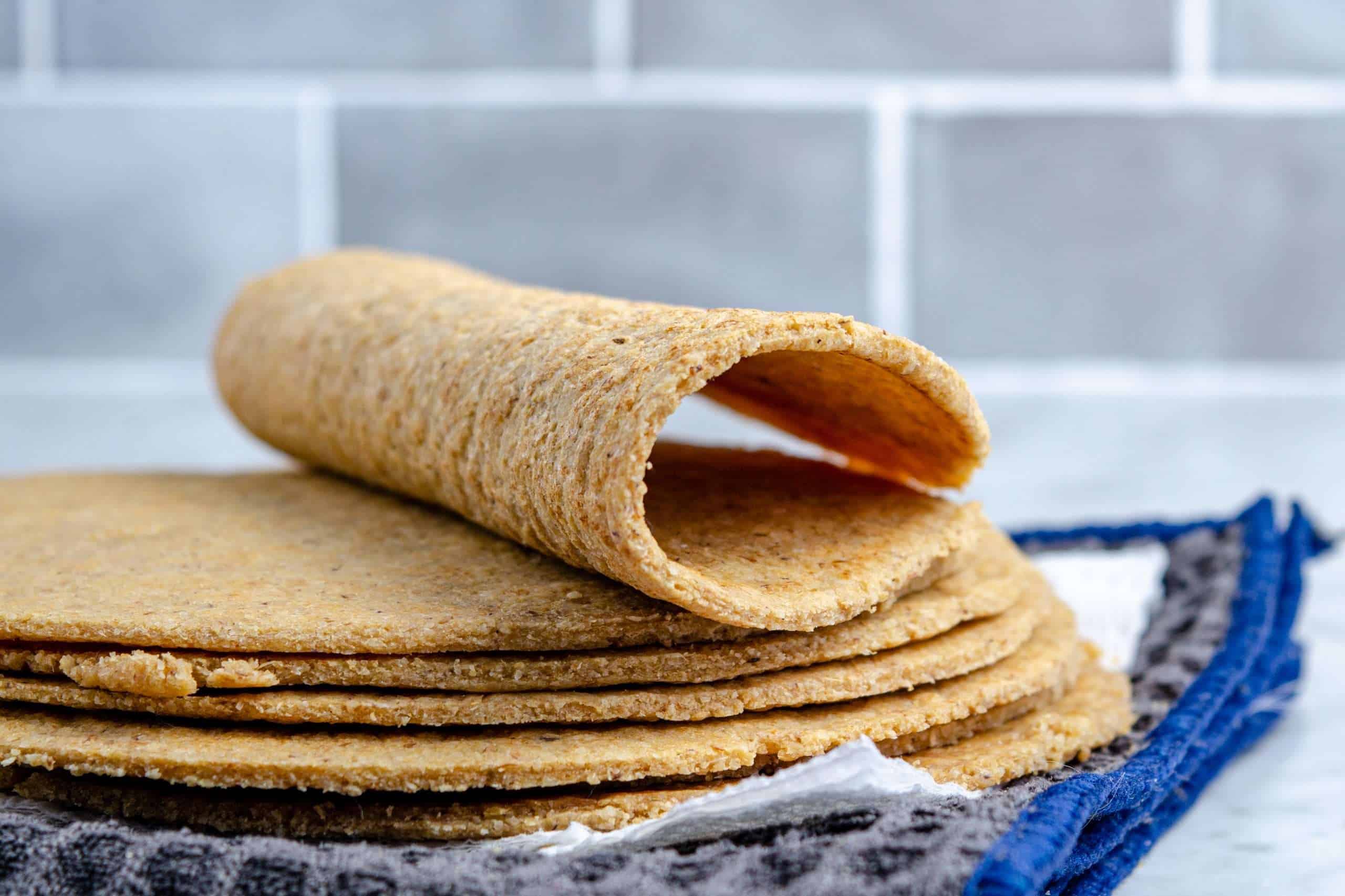 A stack of keto oat fiber and almond flour tortilla with a folded tortilla on top