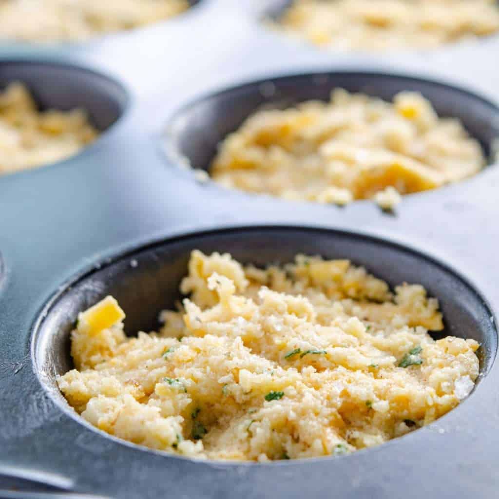 Keto cheese biscuit dough in a muffin tin