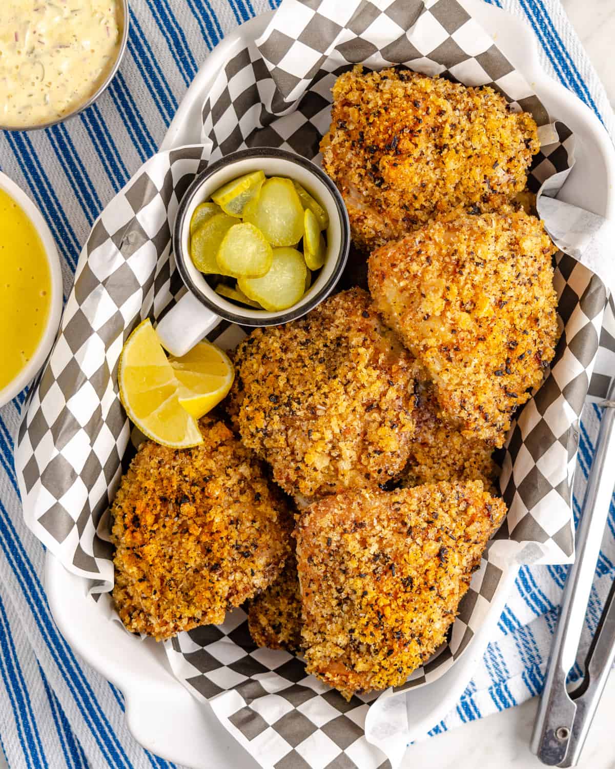 Pork Rind Coated fried chicken ina dish with pickles and remoulade