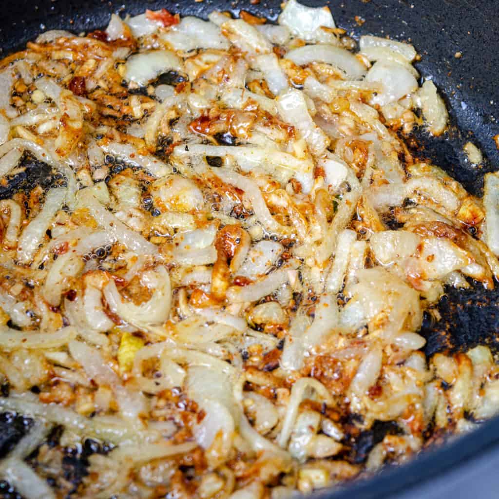 Onions, garlic, and ginger frying in oil for chicken curry
