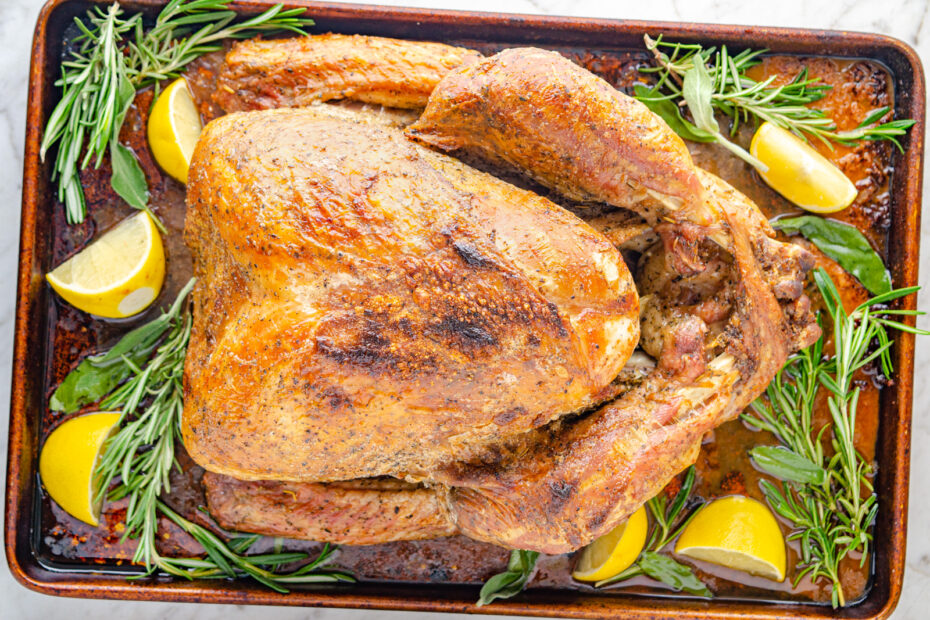 Dry Brined Turkey cooked on a tray with rosemary and lemons