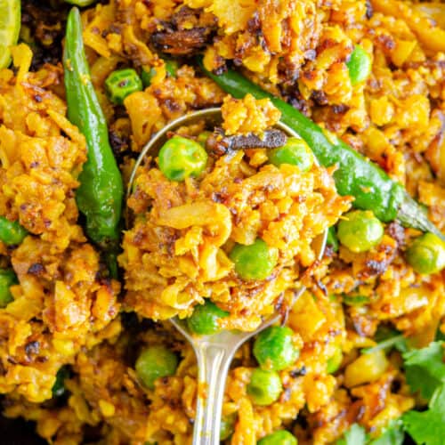 Golden Turmeric Cauliflower rice on a spoon garnished with hot chilies.