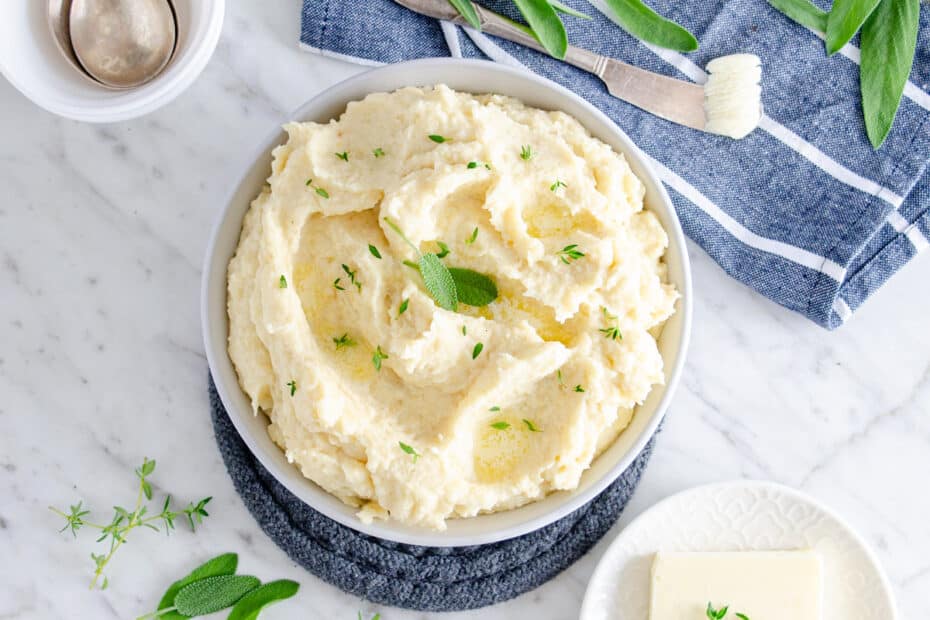Low carb keto friendly mashed celeriac in a grey bowl on a marble background.