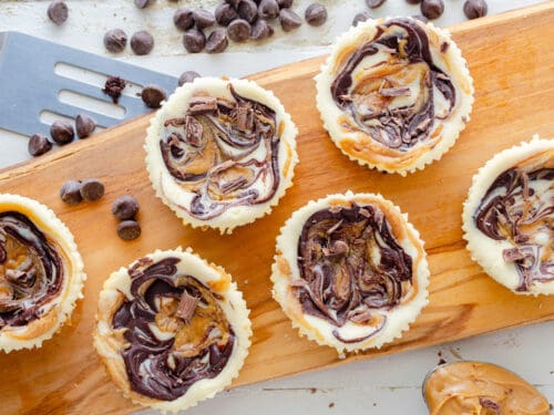 Chocolate Peanut Butter Mini Keto cheesecakes on a wooden board