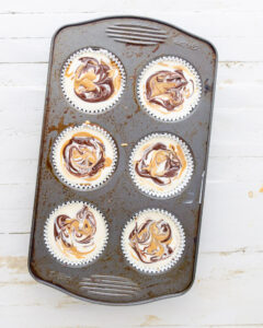 Chocolate and peanut butter swirled into the top of unbaked mini cheesecakes.