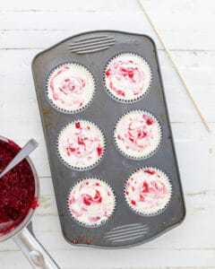 Swirling cran raspberry jam into unbaked keto cheesecakes.