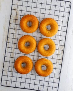 Fully baked keto pumpkin spice donuts cooling on a rack.