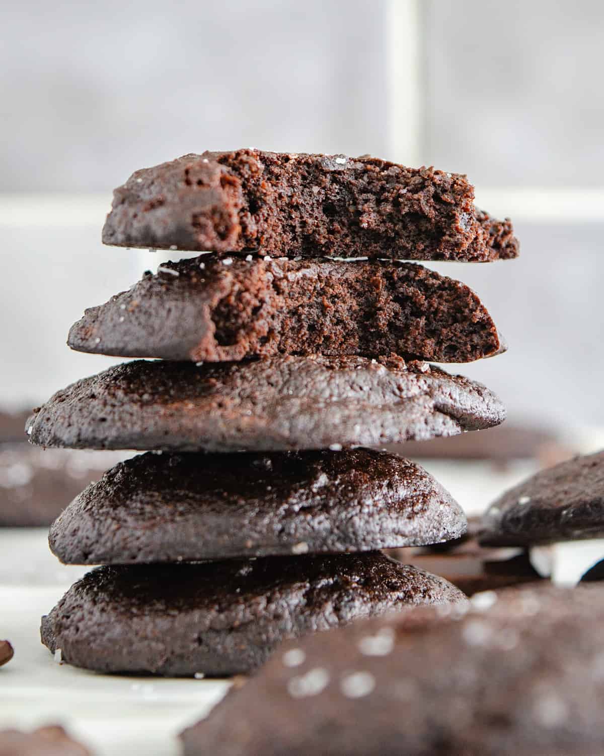 A stack of keto mocha brownie cookies with a bit out of them.